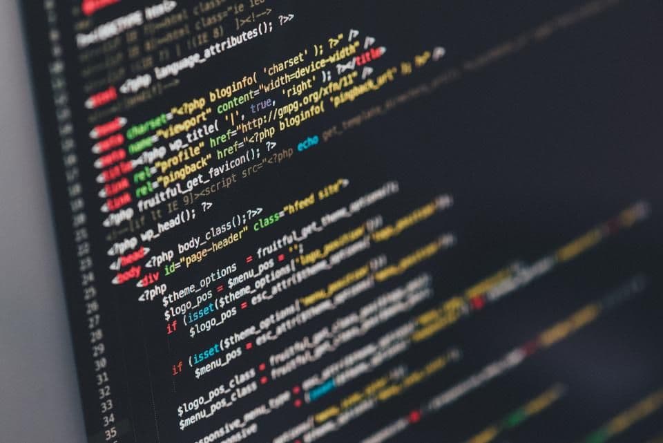 Arbeitsplatz mit Programmcode auf dem Bildschirm